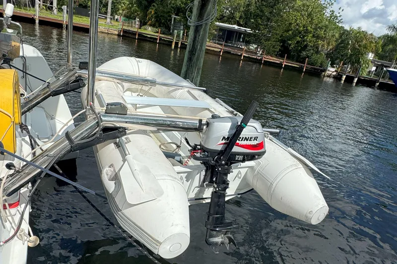 Slide: The Image of Inflatable boat with Mariner outboard motor on Lagoon 40, 2022 model, docked by water. - 58