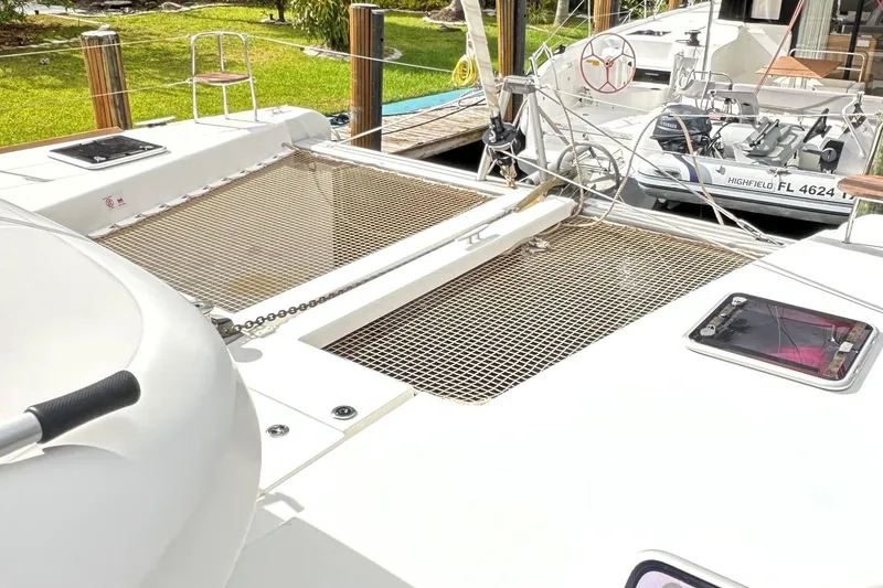 Slide: The Image of 2022 Lagoon 40 catamaran deck with netting and docked boat in background. - 8