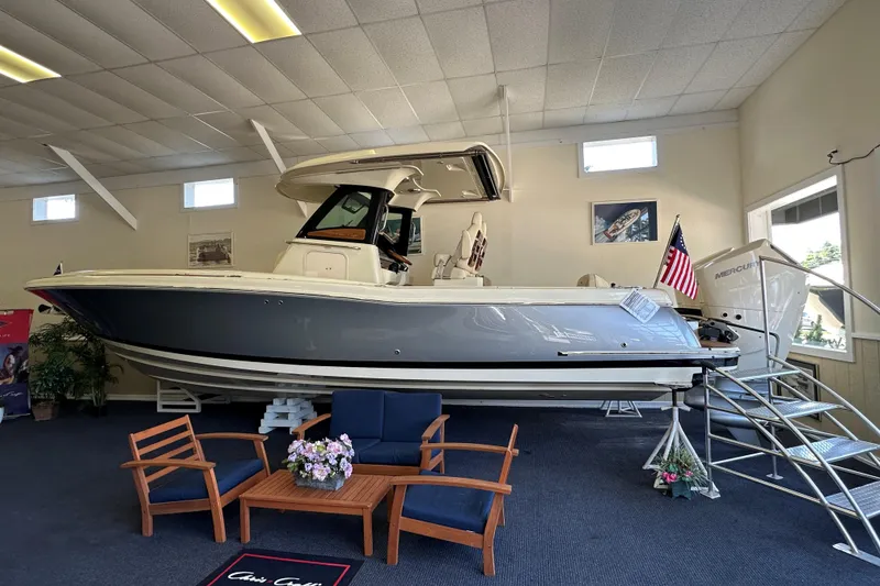 The Image of 2026 Chris-Craft Catalina 31 boat displayed indoors with seating and American flag. - 0