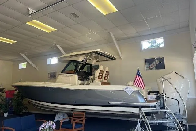 Slide: The Image of 2026 Chris-Craft Catalina 31 boat displayed indoors with American flag. - 2