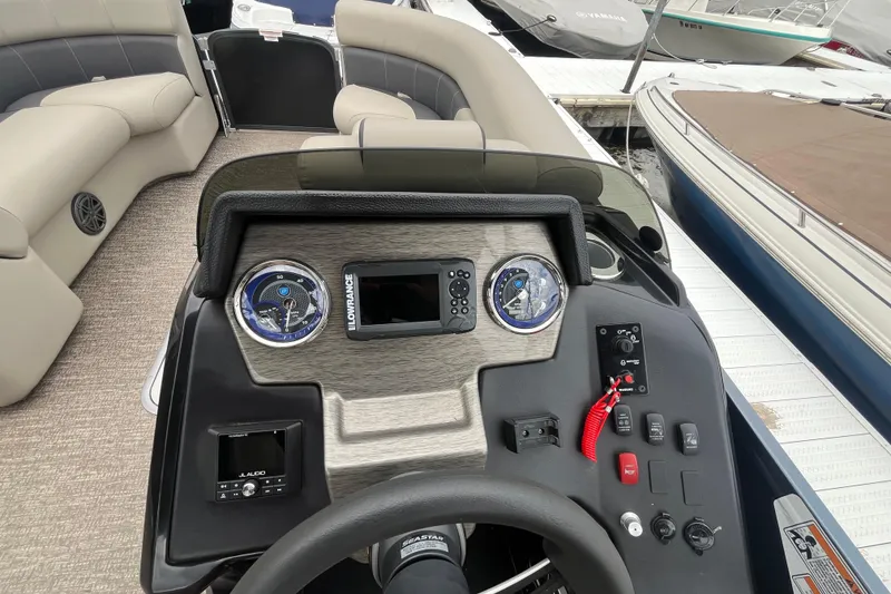Slide: The Image of 2020 Premier 230 SunSation RF boat dashboard with gauges and controls at marina. - 42
