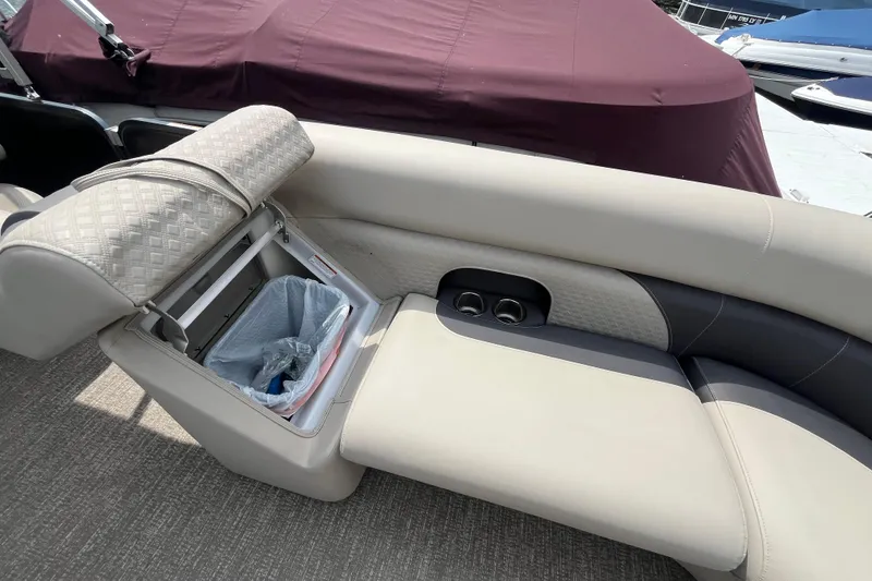 Slide: The Image of 2020 Premier 230 SunSation RF boat interior with built-in storage and trash bin. - 53