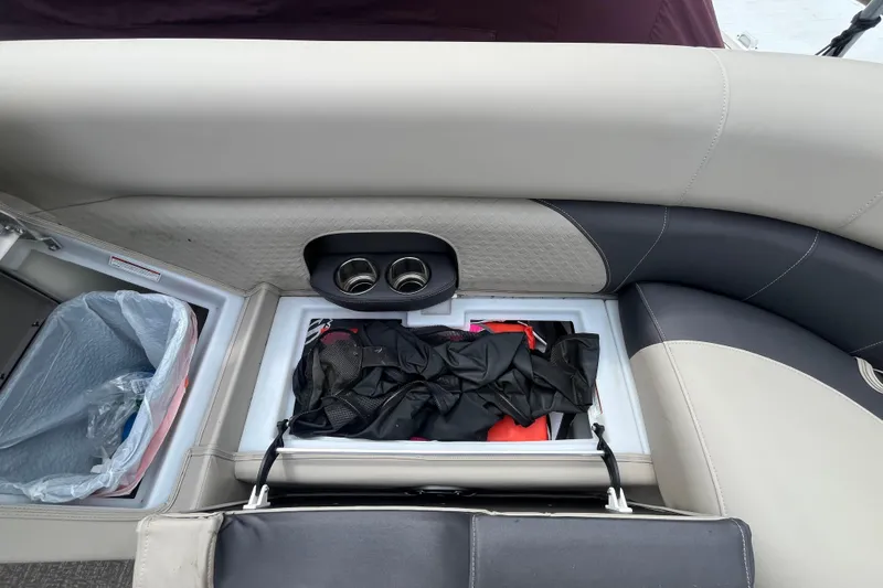 Slide: The Image of 2020 Premier 230 SunSation RF boat interior storage with cup holders and trash bin. - 54