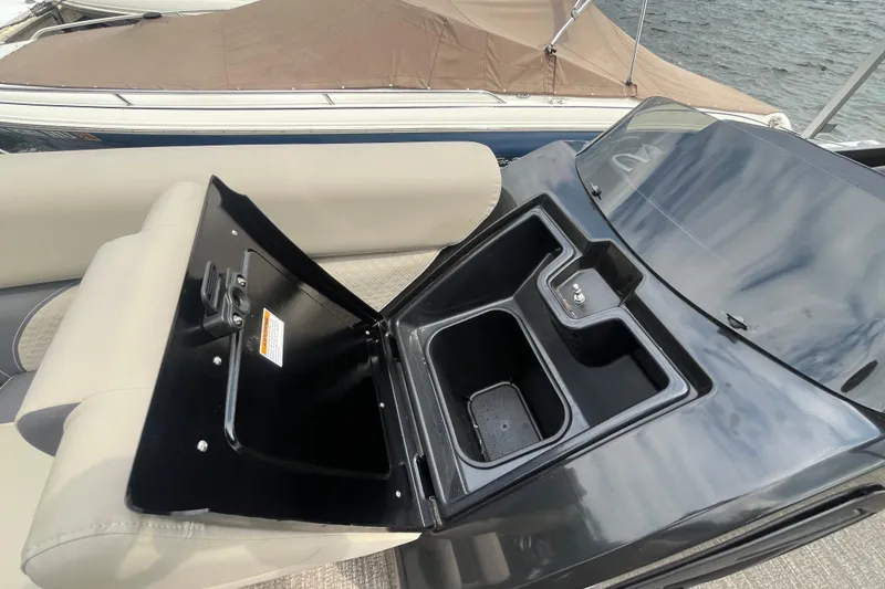 Slide: The Image of Open storage compartment on 2020 Premier 230 SunSation RF boat, featuring cup holders and seating. - 57