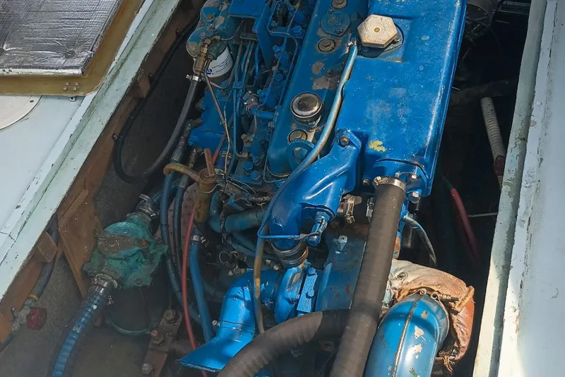 Slide: The Image of Engine compartment of a 1981 Dyer 29 boat, featuring a blue marine engine. - 14
