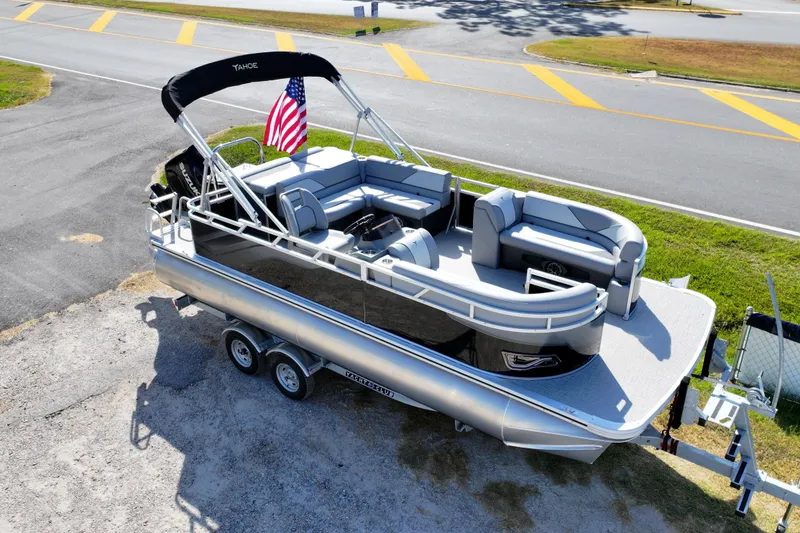 Slide: The Image of 2026 Tahoe Pontoon Sport 85 Cruise boat parked outside dealership under blue sky. - 13