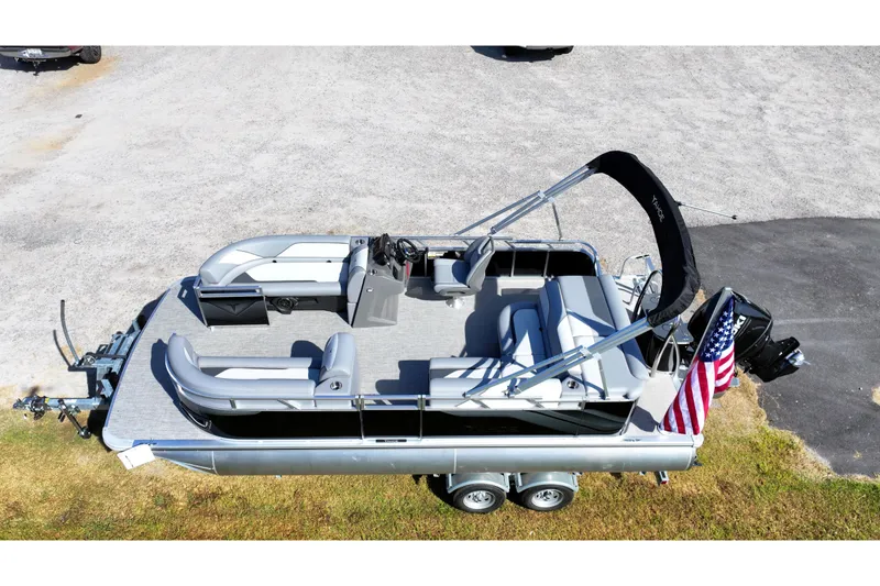 Slide: The Image of 2026 Tahoe Pontoon Sport 85 Cruise boat parked outside dealership under blue sky. - 7