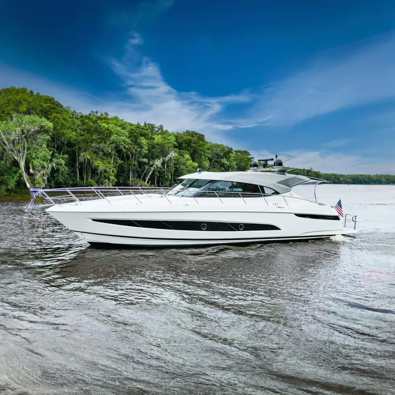 Slide: The Image of 2021 Riviera 5400 Sport Yacht Platinum Edition cruising on a scenic river. - 1