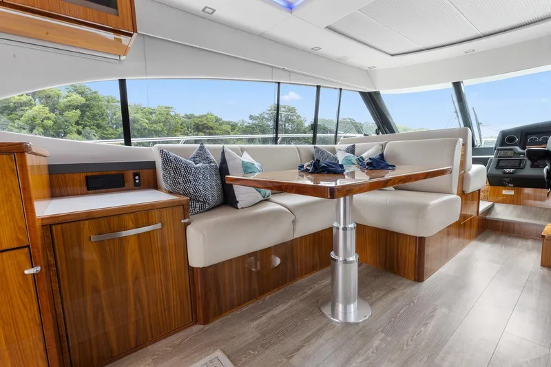 Slide: The Image of Luxurious interior of 2021 Riviera 5400 Sport Yacht Platinum Edition with elegant seating and table. - 23