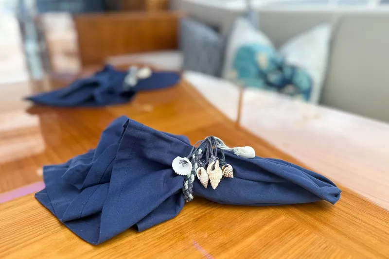 Slide: The Image of Nautical-themed napkin with seashells on Riviera 5400 Sport Yacht's wooden table, 2021 model. - 28