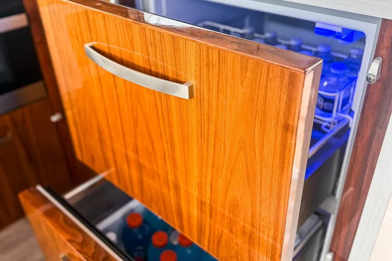 Slide: The Image of Luxury yacht interior with open wooden drawer fridge, showcasing beverages. Riviera 5400 Sport Yacht 2021. - 36