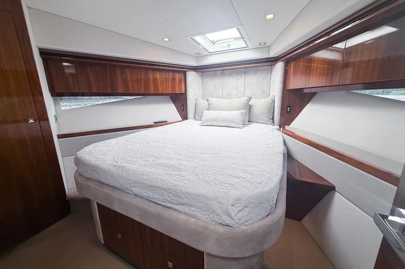 Slide: The Image of Luxurious bedroom in 2021 Riviera 5400 Sport Yacht Platinum Edition with elegant wood finishes. - 49