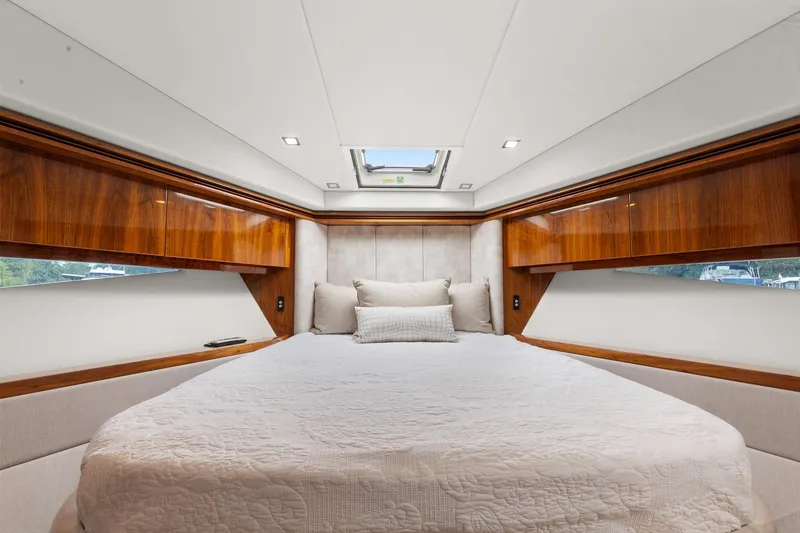 Slide: The Image of Luxurious bedroom interior of 2021 Riviera 5400 Sport Yacht Platinum Edition with elegant wood finishes. - 50