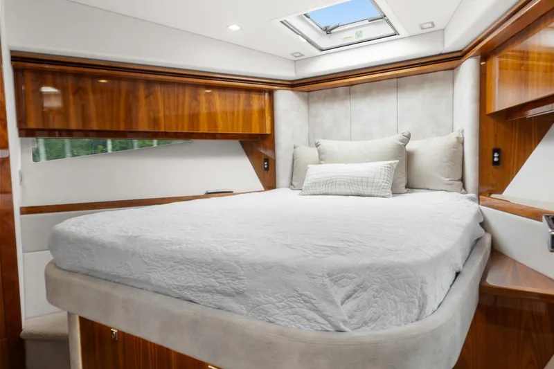 Slide: The Image of Luxurious bedroom interior of 2021 Riviera 5400 Sport Yacht Platinum Edition with elegant wood finishes. - 51