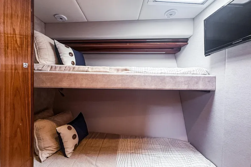 Slide: The Image of Interior of 2021 Riviera 5400 Sport Yacht Platinum Edition with cozy bunk beds. - 57