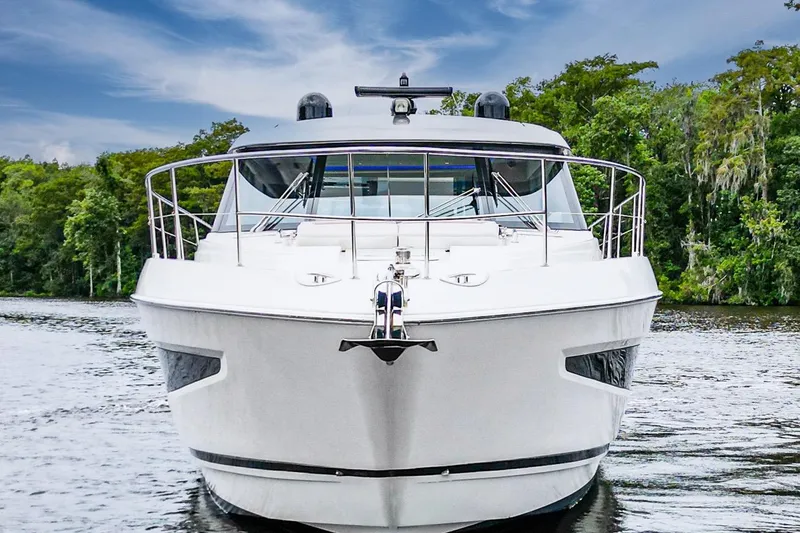Slide: The Image of 2021 Riviera 5400 Sport Yacht Platinum Edition on a serene waterway. - 6