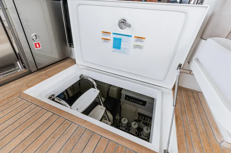 Slide: The Image of 2021 Riviera 5400 Sport Yacht engine compartment with open hatch and visible equipment. - 71