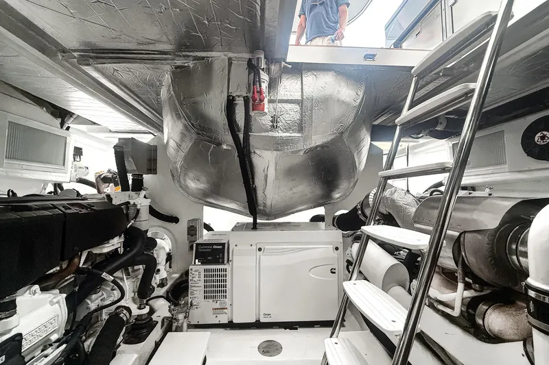 Slide: The Image of Engine room of 2021 Riviera 5400 Sport Yacht Platinum Edition with visible machinery and ladder. - 73