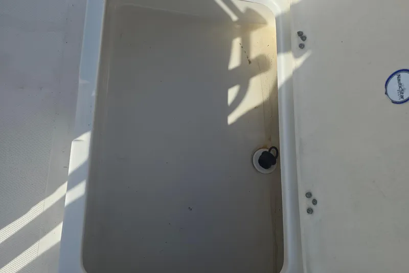 Slide: The Image of Storage compartment of 2009 NauticStar 2200 Nautic Bay boat, featuring drainage plug. - 11