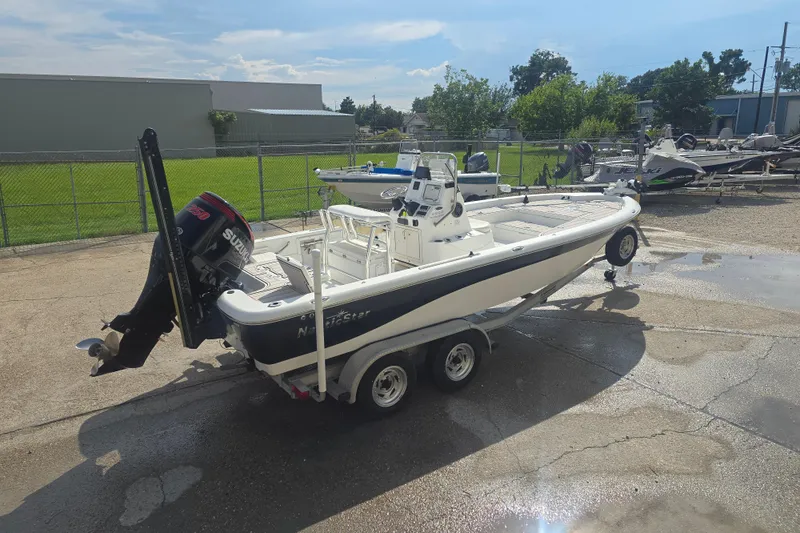 Slide: The Image of 2009 NauticStar 2200 Nautic Bay boat on trailer with Suzuki outboard motor. - 2