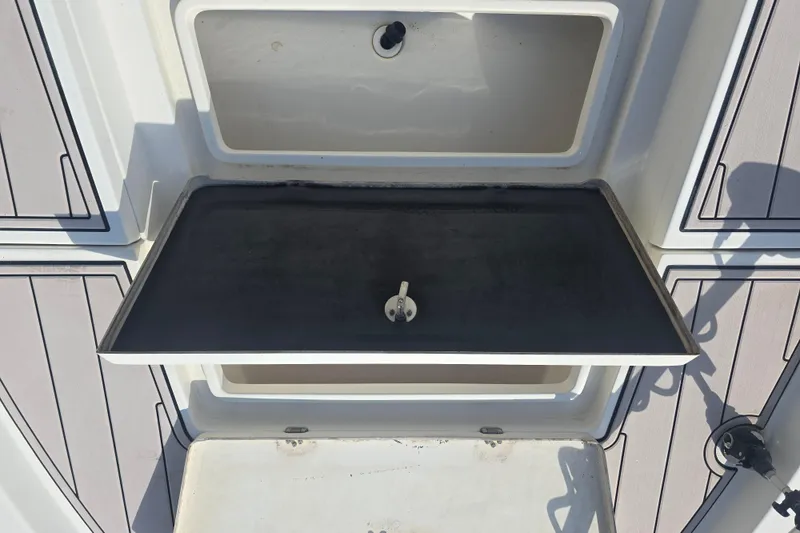 Slide: The Image of 2009 NauticStar 2200 Nautic Bay boat storage compartment with open lid and clean interior. - 9