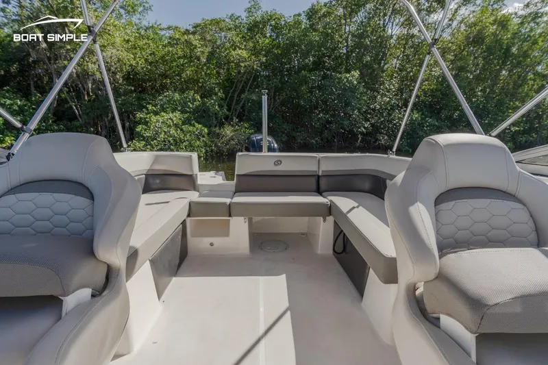 Slide: The Image of 2022 Hurricane SunDeck 217 OB boat interior with spacious seating and lush greenery background. - 8