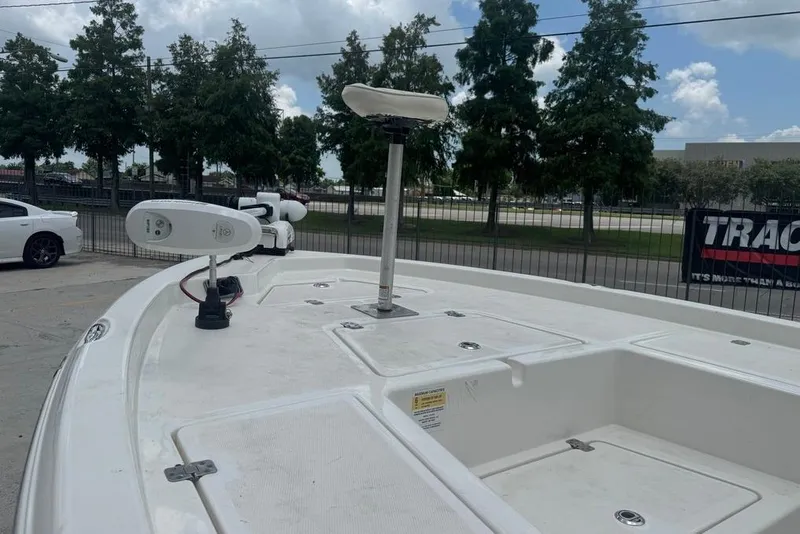 Slide: The Image of 2022 NauticStar 215 XTS boat deck with trolling motor, parked outdoors. - 12