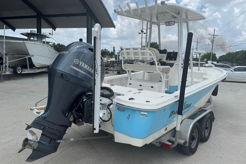 Slide: The Image of 2022 NauticStar 215 XTS boat with Yamaha outboard motor, parked on a trailer. - 7