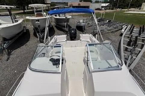 Slide: The Image of 2002 Pro-Line 20 DC boat with blue canopy, parked on gravel lot. - 10