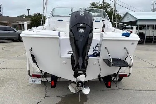 Slide: The Image of 2002 Pro-Line 20 DC boat with outboard motor, parked on concrete. - 11