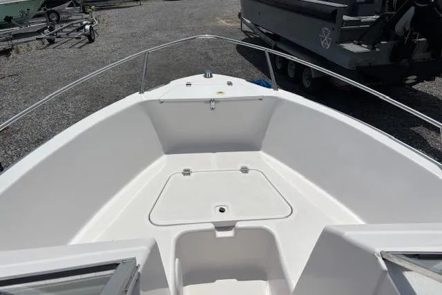 Slide: The Image of 2002 Pro-Line 20 DC boat deck with storage compartment, parked on gravel. - 12