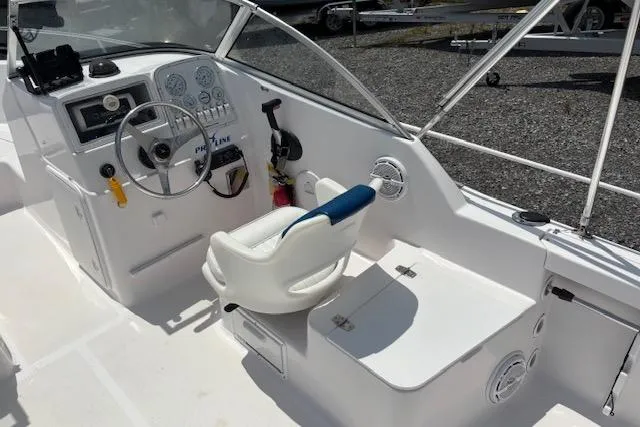 Slide: The Image of 2002 Pro-Line 20 DC boat cockpit with steering wheel, gauges, and white seating. - 5