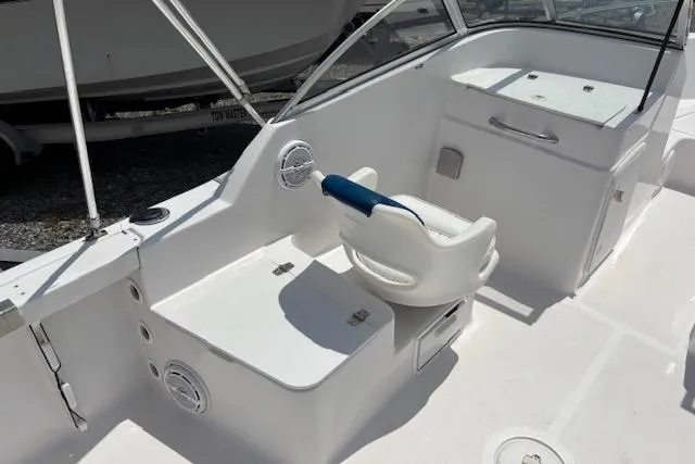 Slide: The Image of 2002 Pro-Line 20 DC boat interior with white seating and storage compartments. - 6