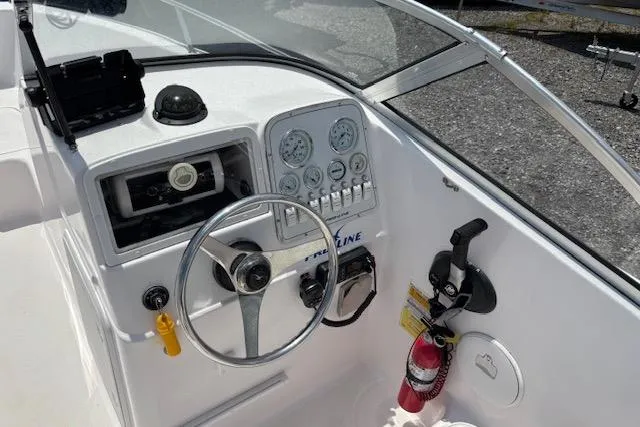 Slide: The Image of 2002 Pro-Line 20 DC boat dashboard with steering wheel and gauges. - 8