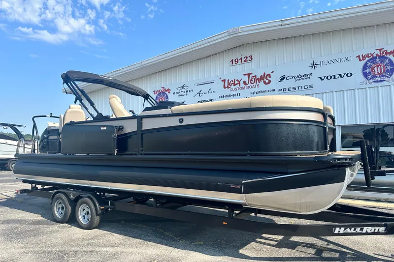 Slide: The Image of 2026 Premier 250 Angler pontoon boat on trailer outside dealership. - 3