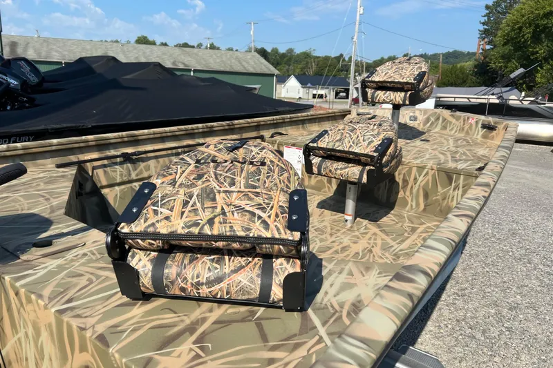 Slide: The Image of 2026 Lund 1660 Predator boat with camouflage seating, displayed outdoors. - 3