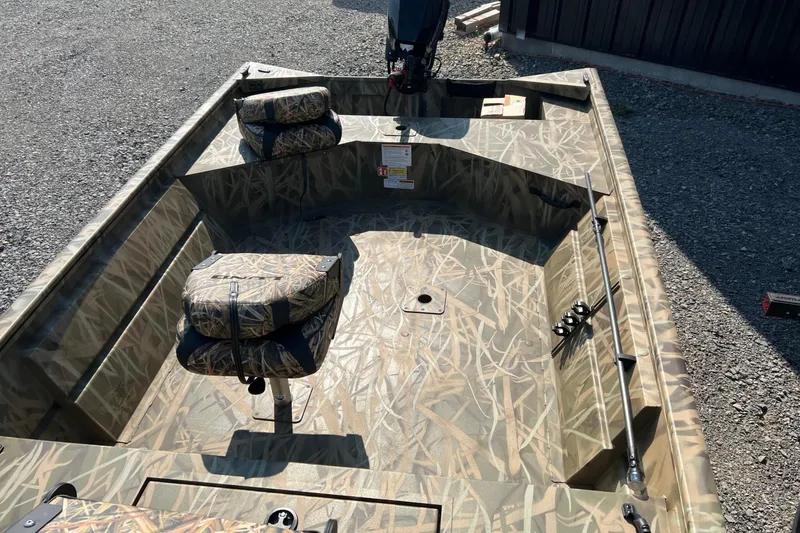 Slide: The Image of 2026 Lund 1660 Predator boat with camouflage interior, featuring swivel seats and fishing rod holders. - 4