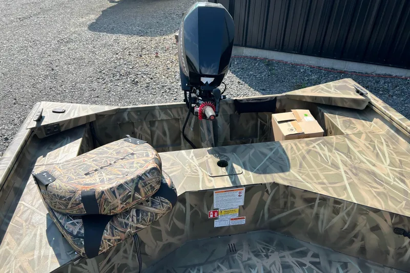 Slide: The Image of 2026 Lund 1660 Predator boat with camouflage design and outboard motor. - 5