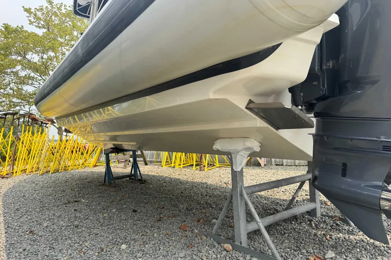 Slide: The Image of 2016 Protector 30 Center Console boat on stands, showing hull and outboard motor. - 16
