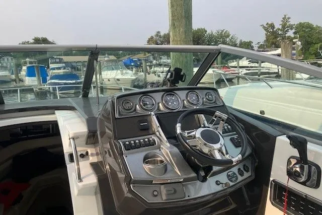 Slide: The Image of Cockpit view of 2016 Monterey 275 Sport Yacht with steering wheel and control panel. - 10