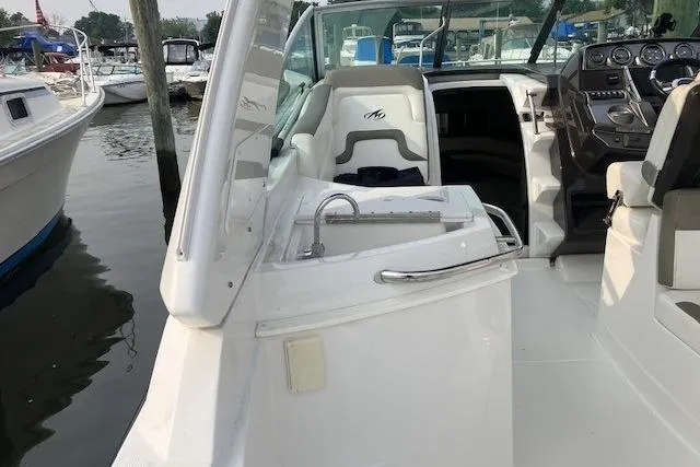 Slide: The Image of 2016 Monterey 275 Sport Yacht interior with seating and helm, docked at marina. - 3