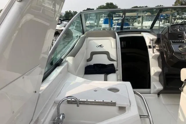 Slide: The Image of 2016 Monterey 275 Sport Yacht interior with seating and control panel, docked at marina. - 4