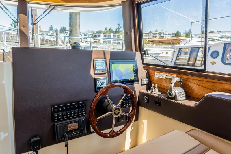 Slide: The Image of 2026 Ranger Tugs R-29 CB helm with navigation controls and steering wheel. - 13