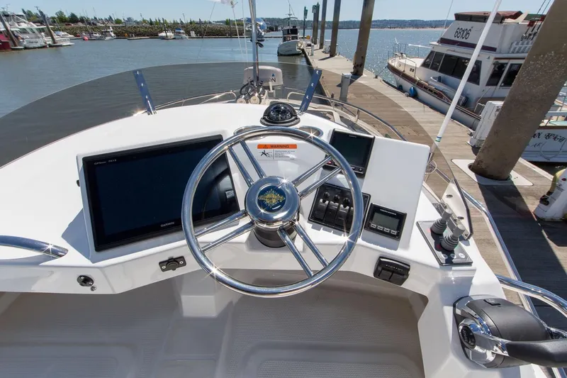 Slide: The Image of 2026 Ranger Tugs R-29 CB helm with modern navigation equipment at marina dock. - 6