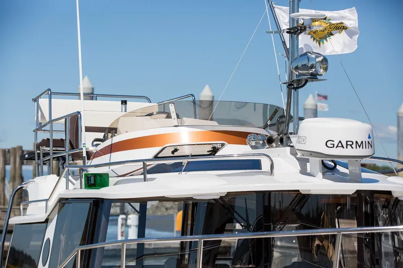 Slide: The Image of 2026 Ranger Tugs R-29 CB boat with Garmin equipment, docked under clear blue sky. - 7