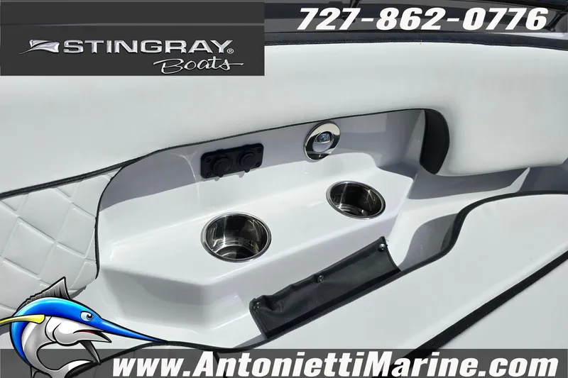 Slide: The Image of 2026 Stingray 259DC boat interior with cup holders, logo, and contact information. - 39