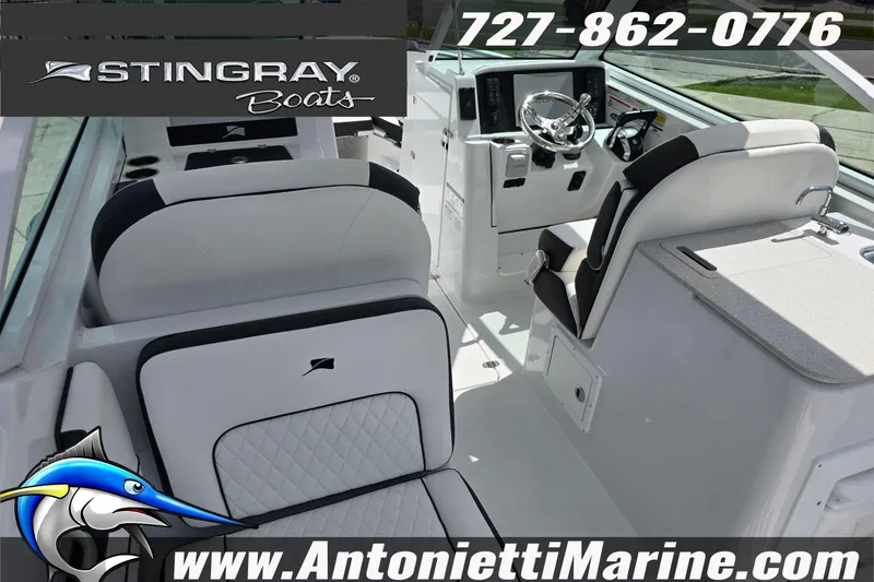 Slide: The Image of Interior view of 2026 Stingray 259DC boat with white seating and dashboard. - 54