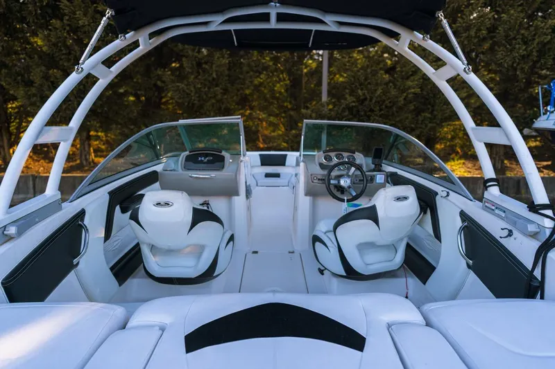 Slide: The Image of 2018 Chaparral 210 Suncoast boat interior with white seating and modern dashboard. - 9
