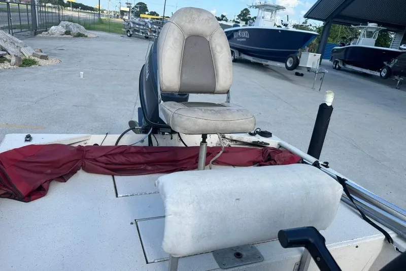 Slide: The Image of 2010 Xpress XP18 boat interior with steering wheel and dashboard, parked in a marina. - 12