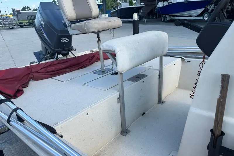 Slide: The Image of 2010 Xpress XP18 boat interior with seating and storage, parked in a marina. - 15
